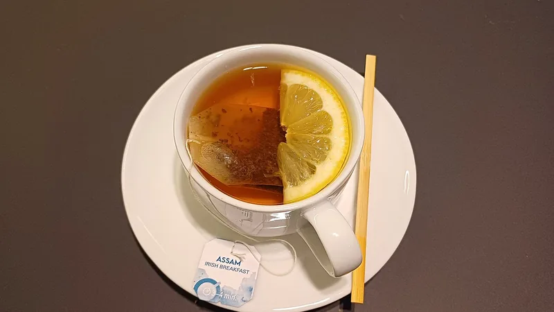 Чашка травяного чая с лимоном у окна